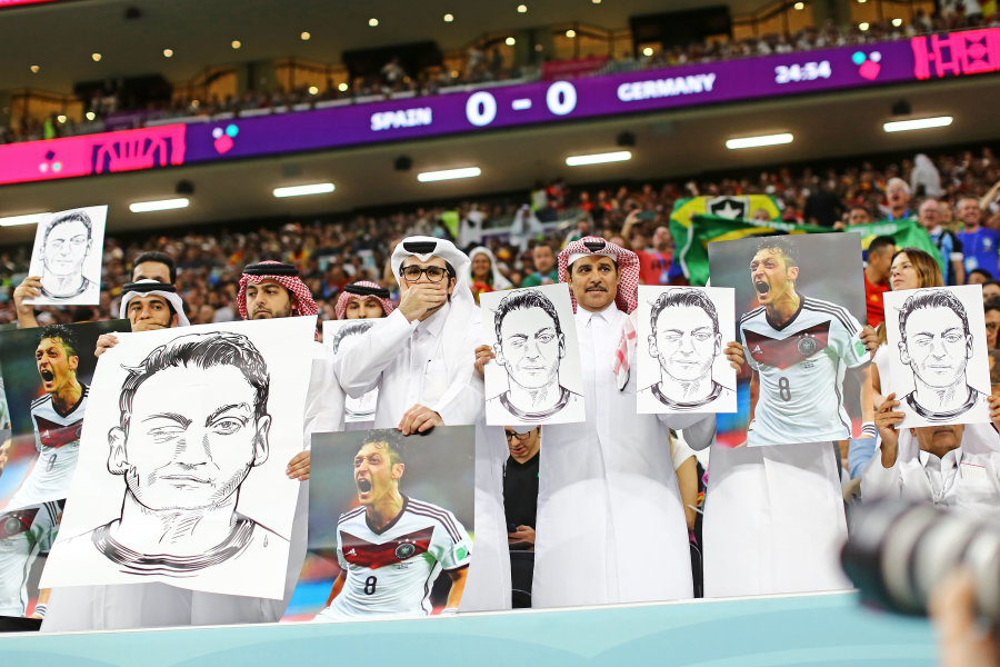 The response of Qatar fans to Germans: waving posters with the image of M. Ozil.